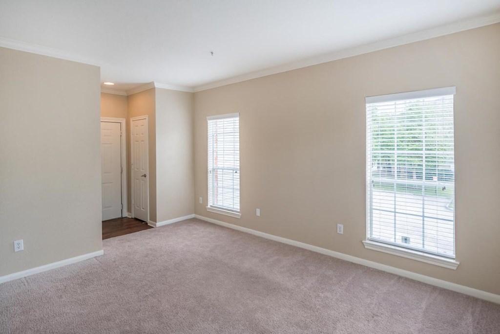 a living room with a large window and carpet