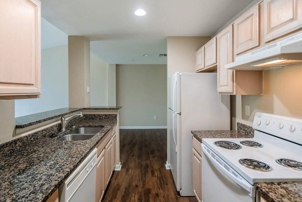 a kitchen with white appliances and granite counter tops