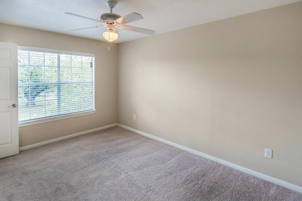 a bedroom with a ceiling fan and a window