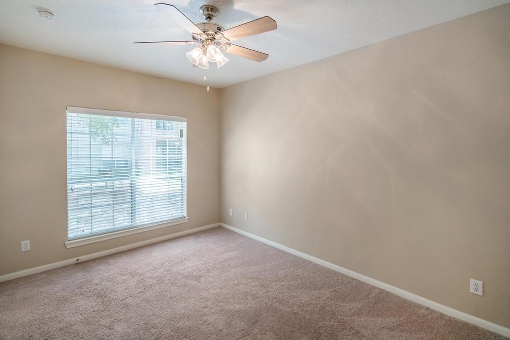 a bedroom with a ceiling fan and a window