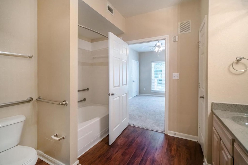 a bathroom with a toilet and a tub and a sink