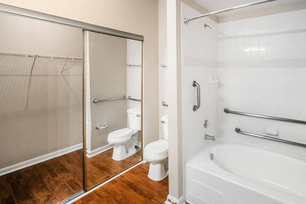 a bathroom with a tub and a toilet and a shower