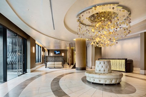 a lobby with a reception area and a large chandelier