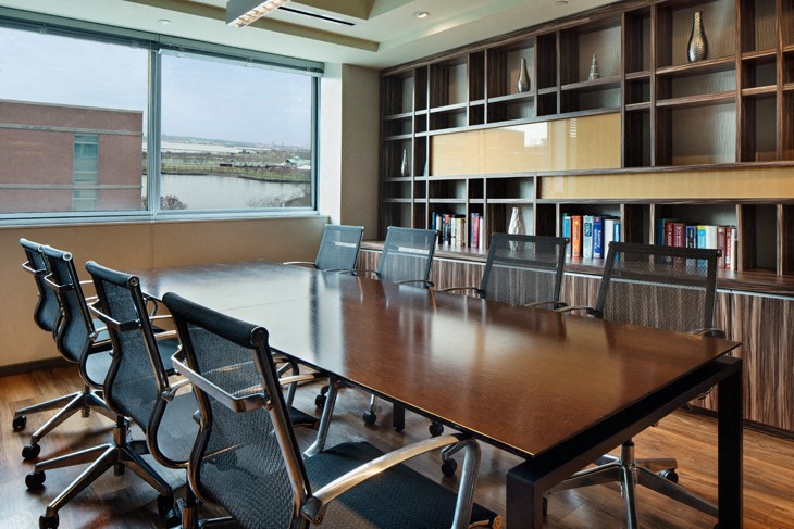 a conference room with a table and chairs and bookshelves