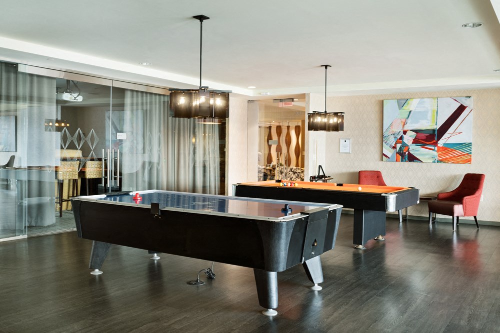 a game room with two pool tables and chairs