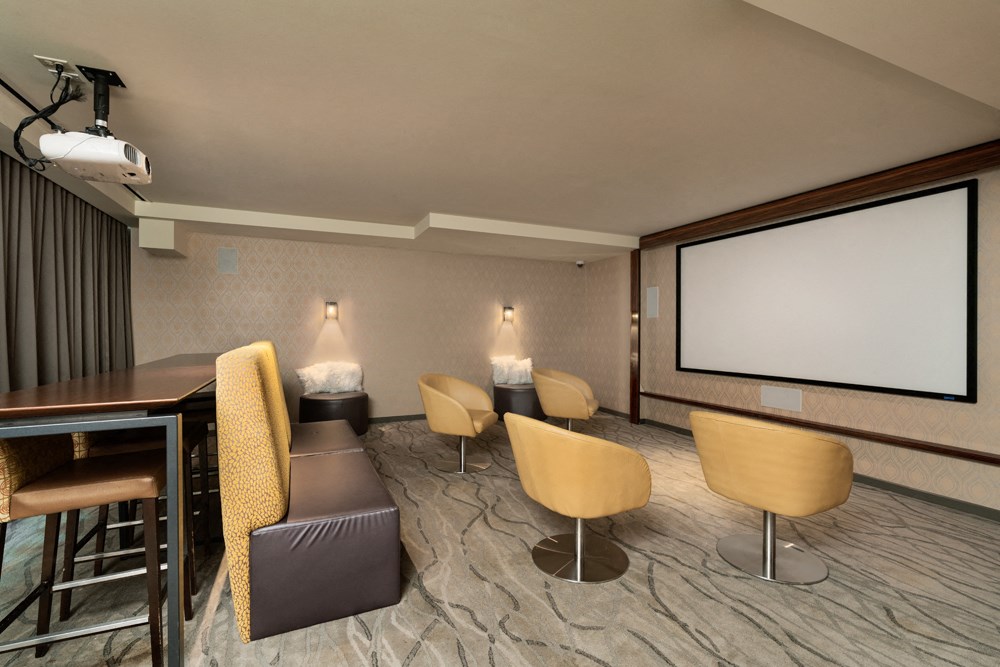 a conference room with a table and chairs and a projector screen