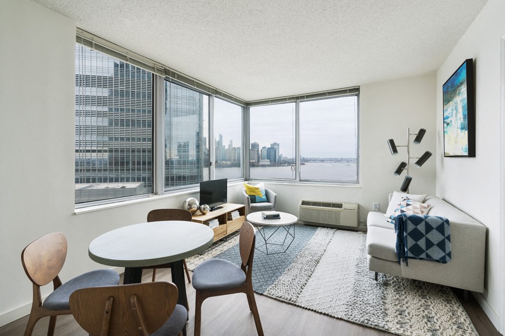 a living room with a large window and a table and chairs