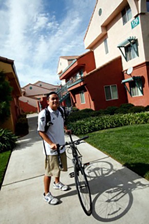 a man standing with a bike on a sidewalk