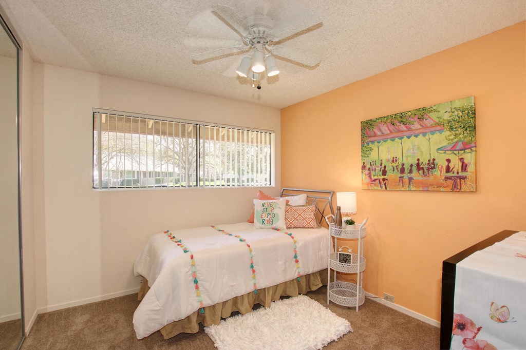 a bedroom with a bed and a ceiling fan
