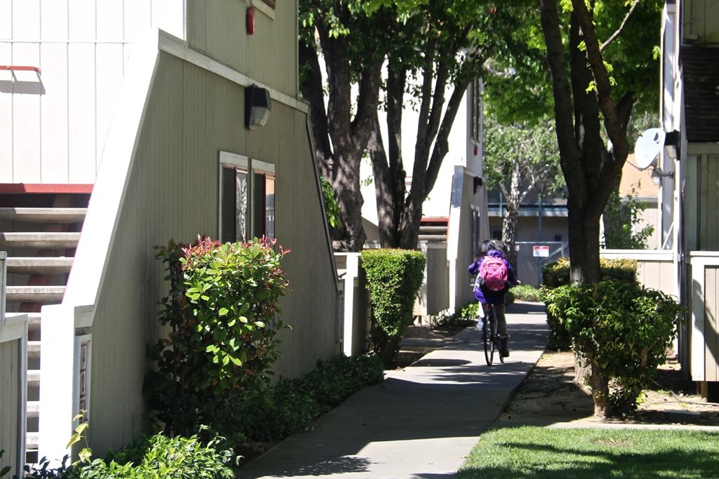 a person riding a bike down a sidewalk