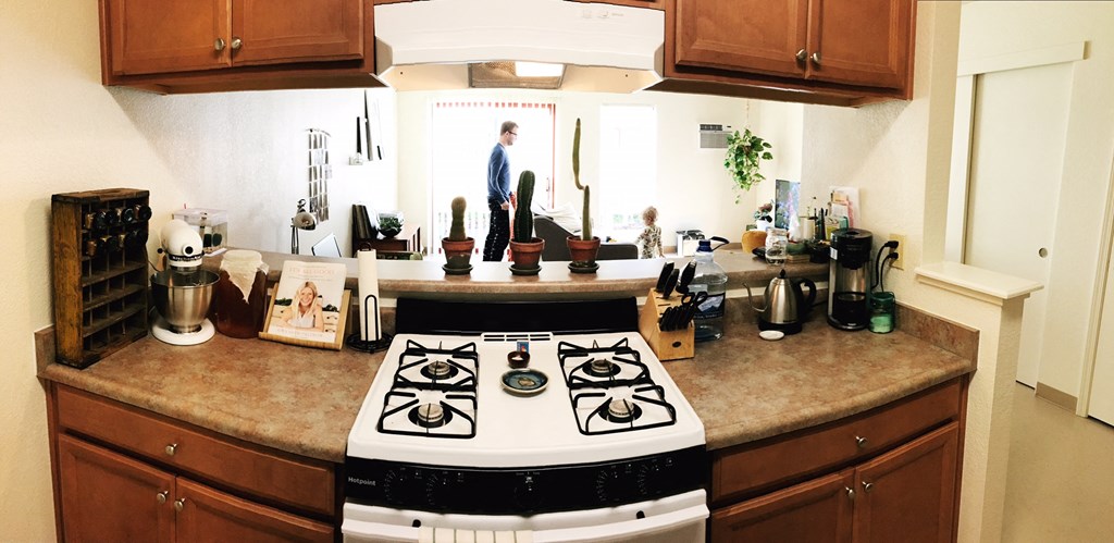 a kitchen with a stove and a person in the window