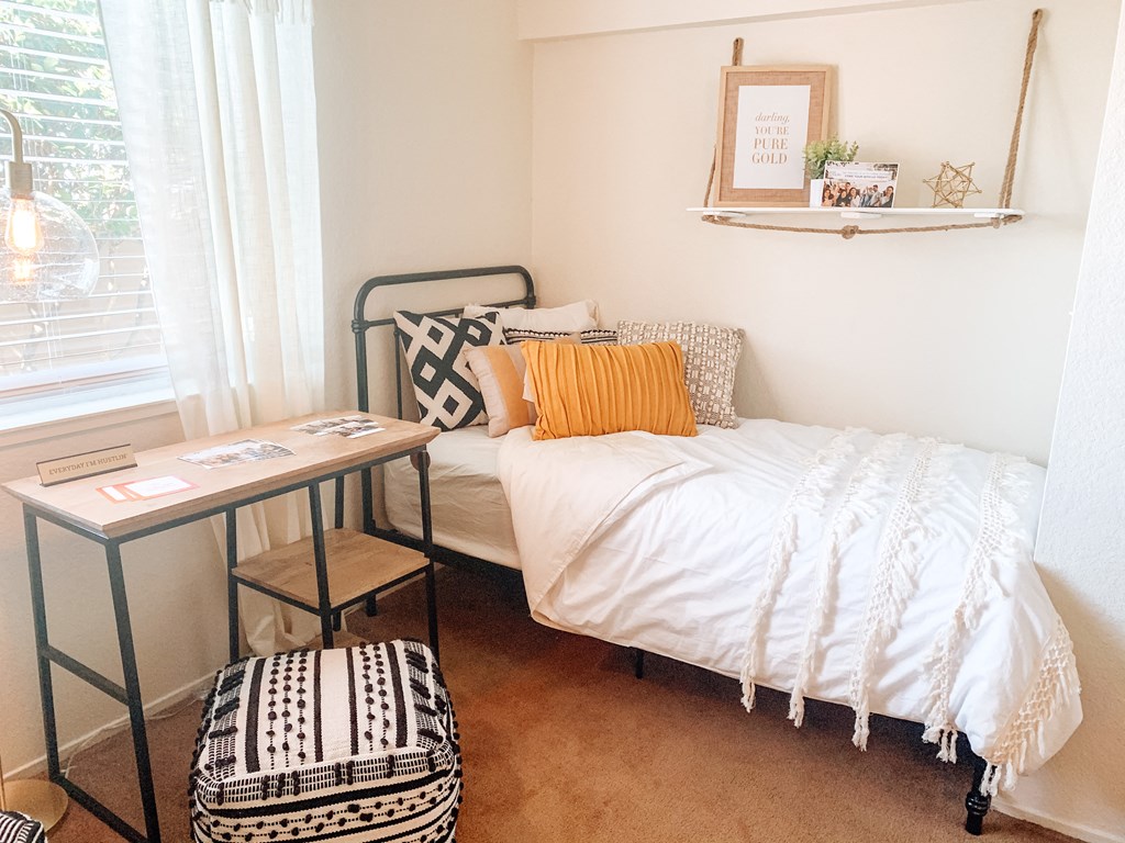 a small bedroom with a bed and a desk