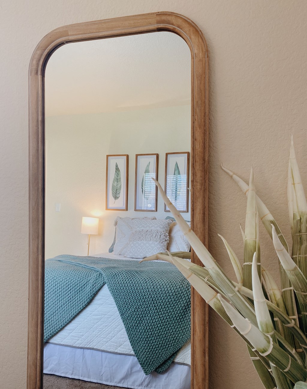 a mirror with a bed reflected in it
