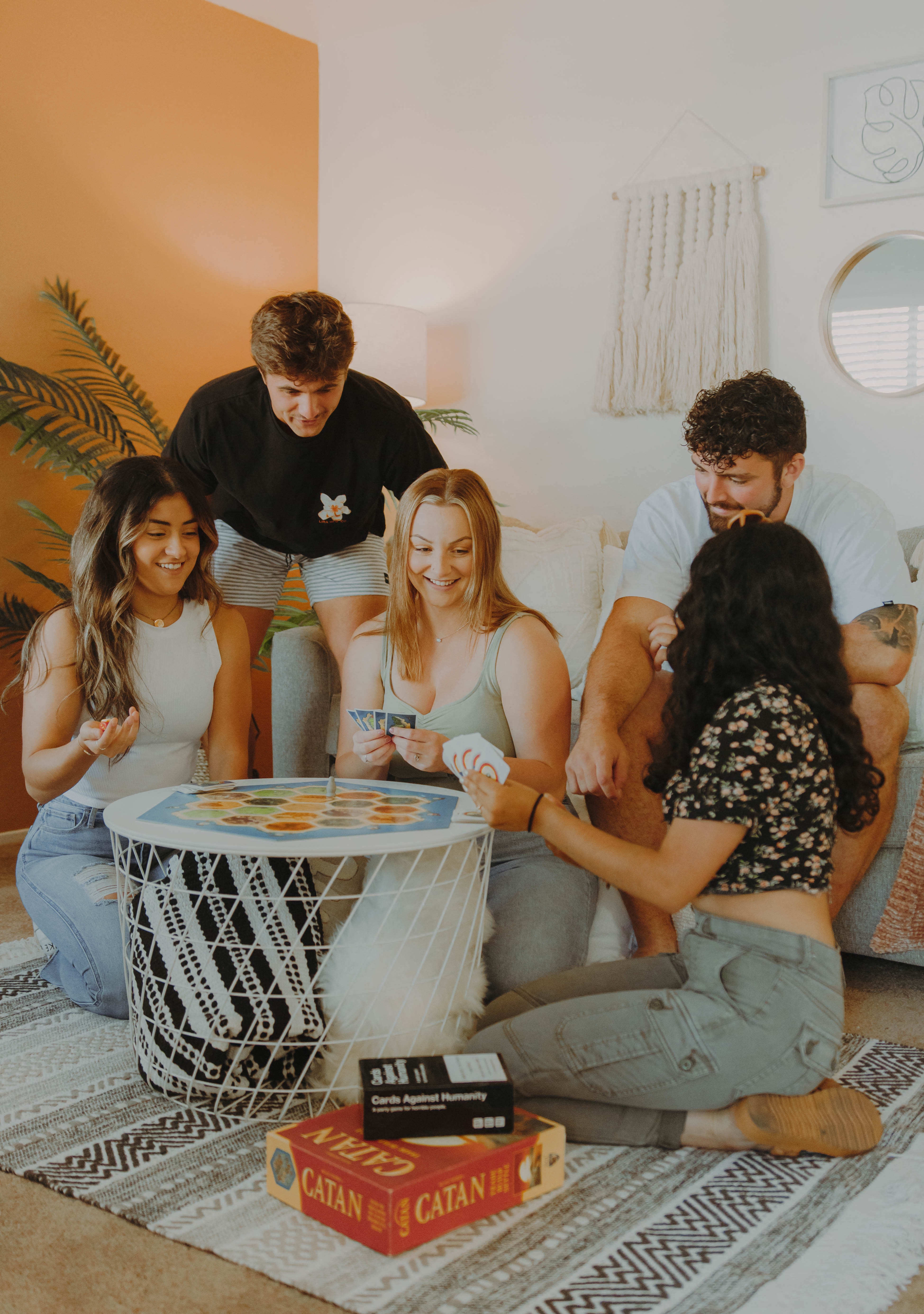 a group of people sitting in a living room playing a card game