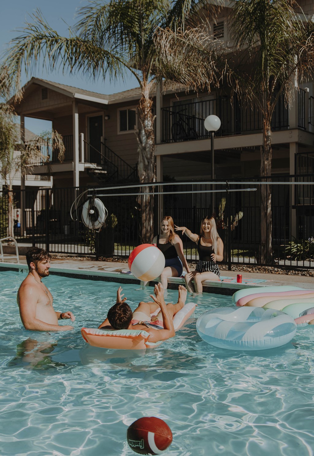 a group of people in a pool playing with a beach ball
