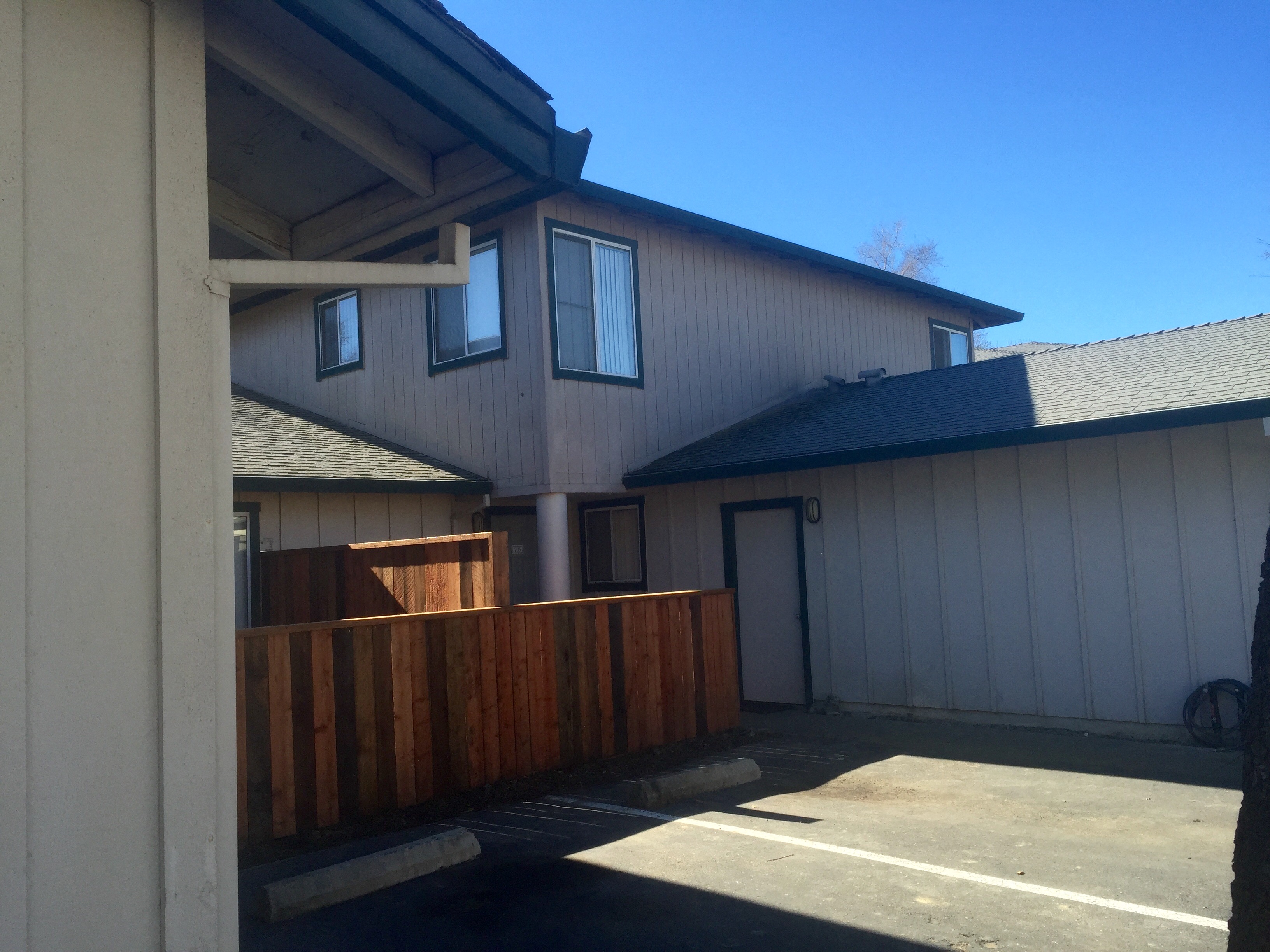 a view of the back of a house with a wood fence and a garage door