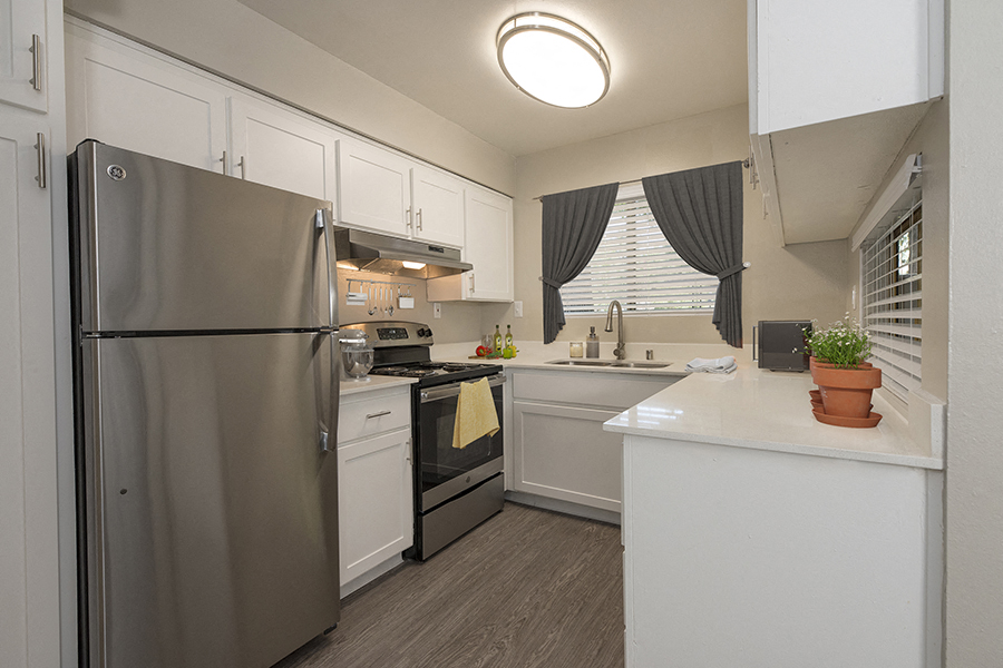 A modern kitchen with a stainless steel refrigerator and a white island.