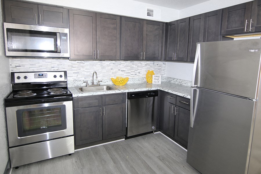 a kitchen with stainless steel appliances and black cabinets
