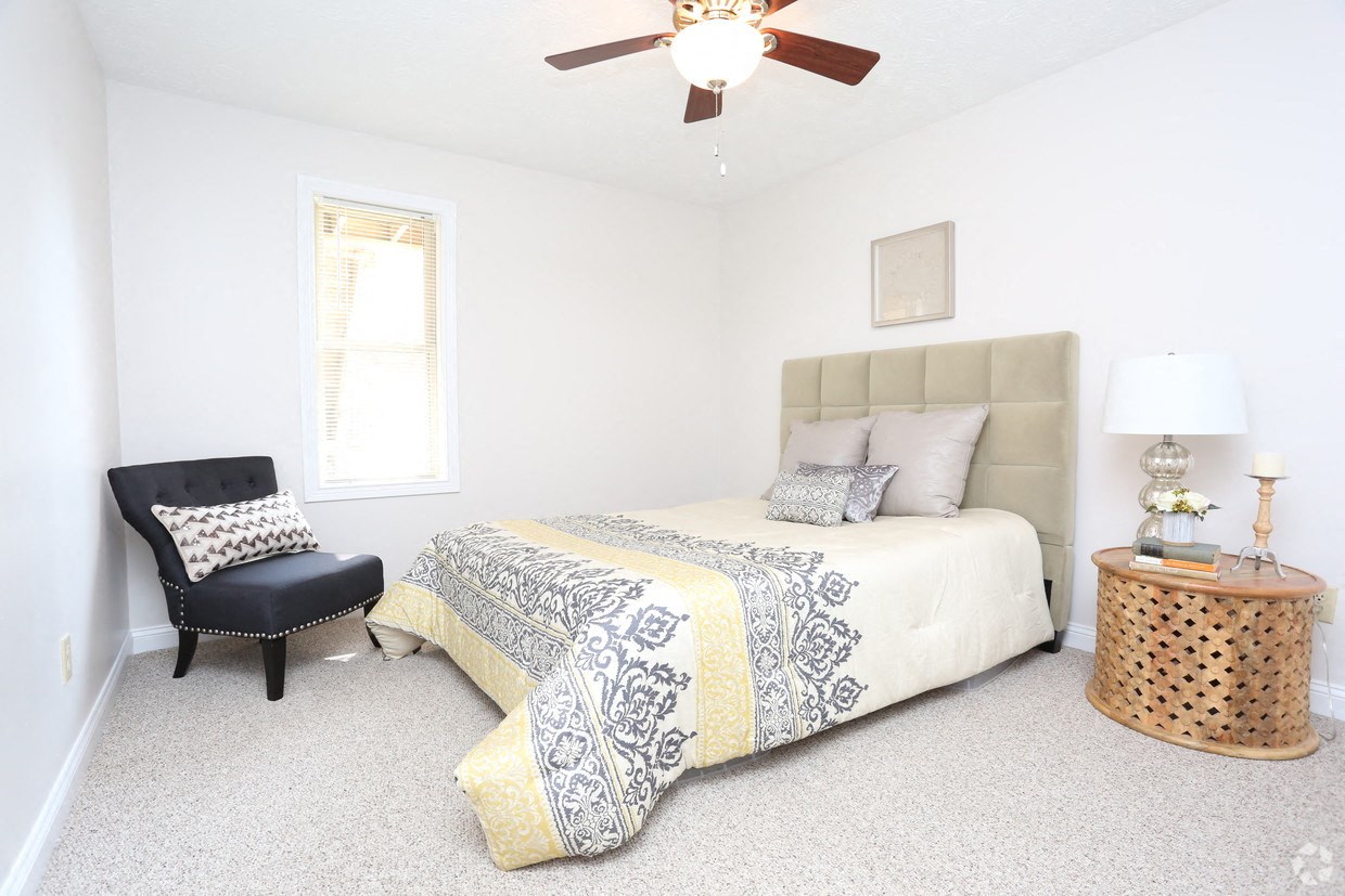 a bedroom with a bed and a ceiling fan