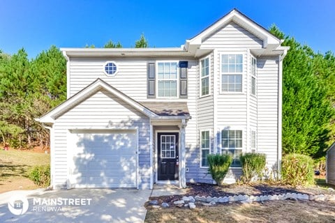 a white house with a white garage door and a blue sky