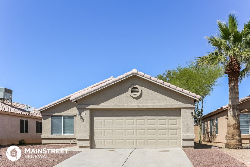 a home with a white garage door and a palm tree