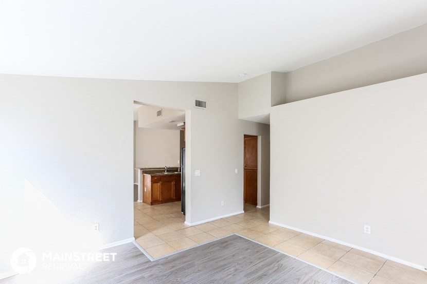 a view of the living room and kitchen of an empty house