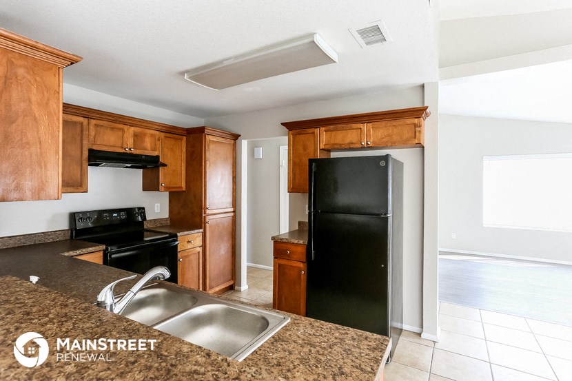 a kitchen with black appliances and wooden cabinets and granite counter tops