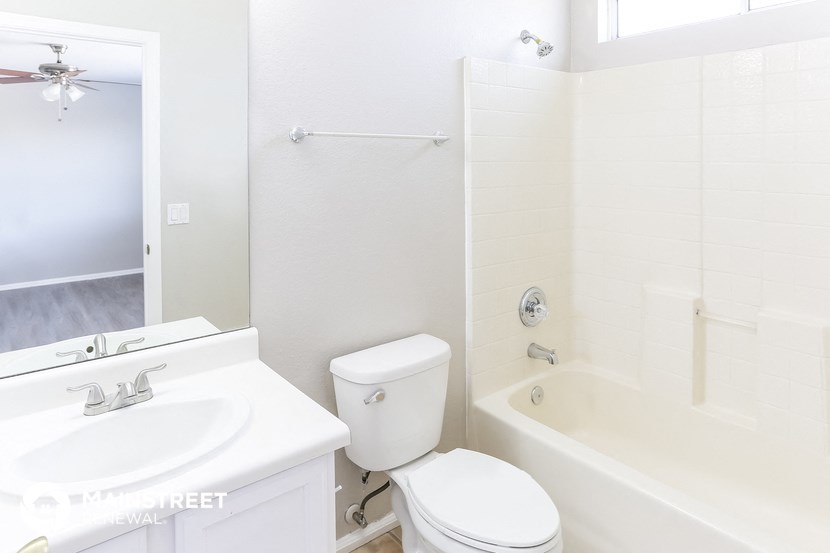 a white bathroom with a tub and a toilet and a sink
