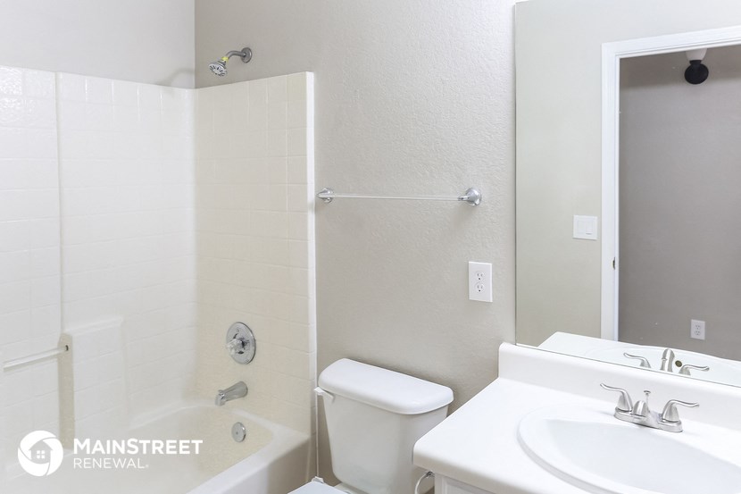 a bathroom with a sink toilet and shower and a mirror