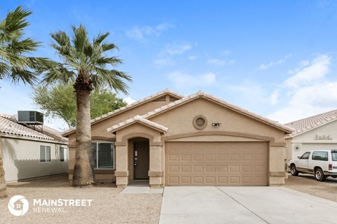 a home with a palm tree and a garage door
