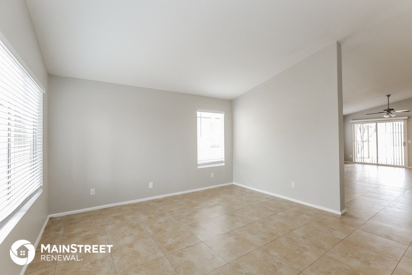 the spacious living room and dining room are spacious with tile floors and white walls