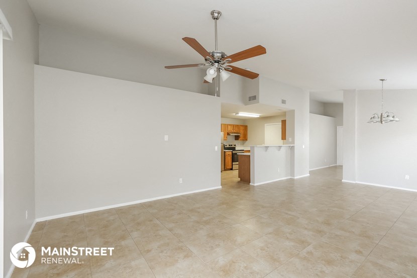 the living room and kitchen are spacious with tile flooring and a ceiling fan