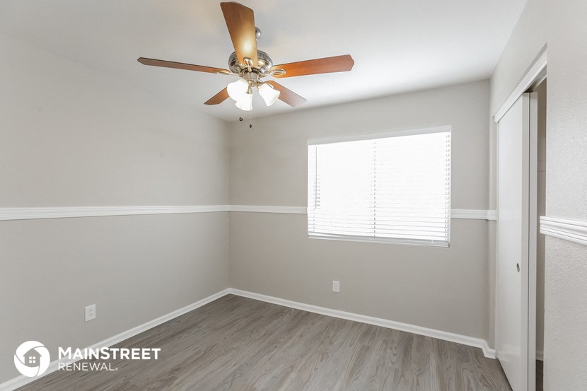 a bedroom with a ceiling fan and a window