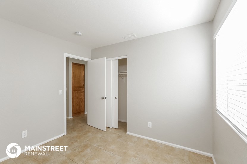 a master bedroom with a door to the closet and a hallway to the bathroom