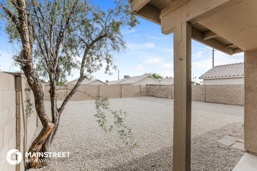 a yard with a tree and a house in the background