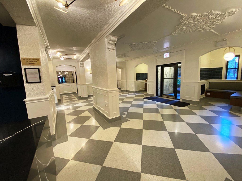 the lobby of a building with a checkered floor and a door