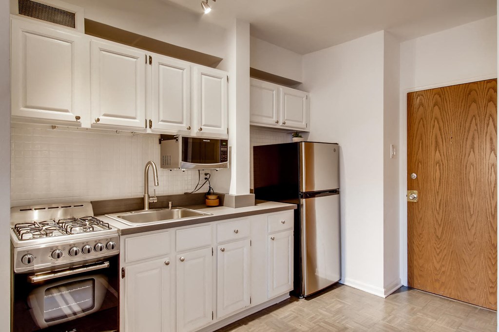 a kitchen with white cabinets and a stainless steel refrigerator