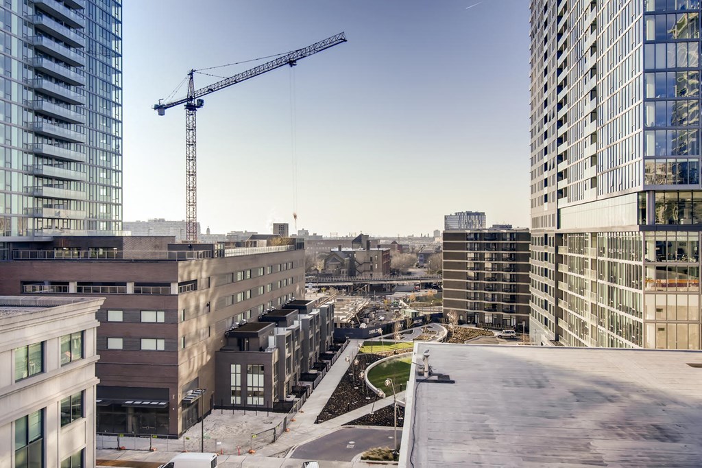 a construction crane in the middle of a city with tall buildings