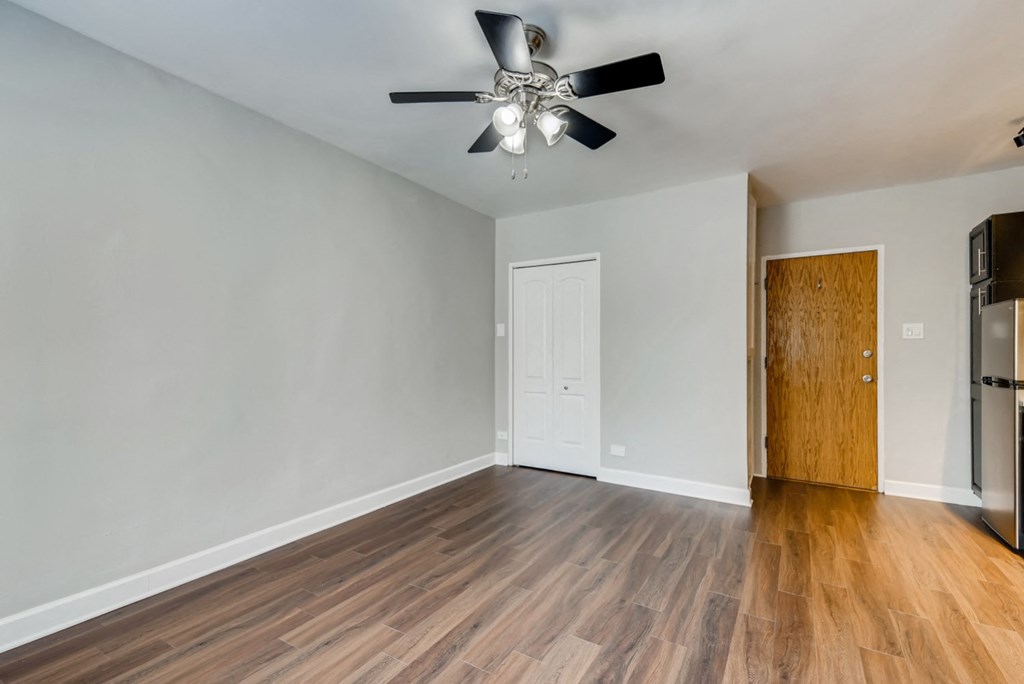 the living room of an empty house with a ceiling fan