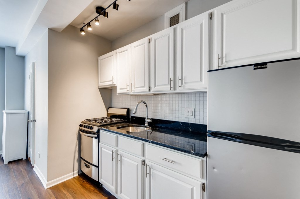 a kitchen with white cabinets and a stove and refrigerator