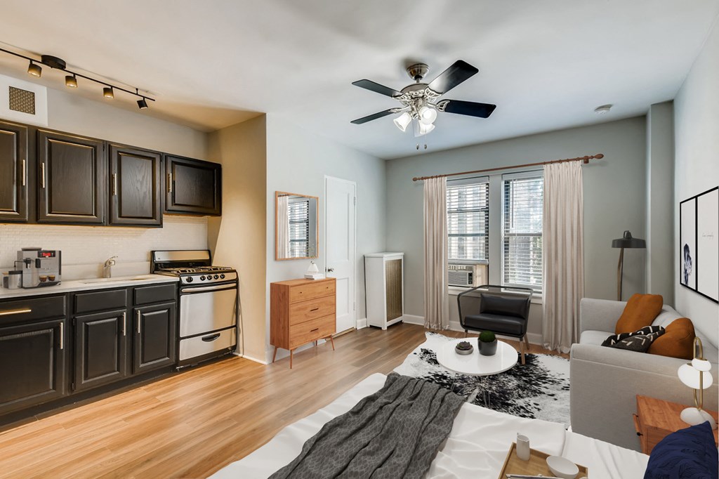 an open living room with a kitchen and a ceiling fan