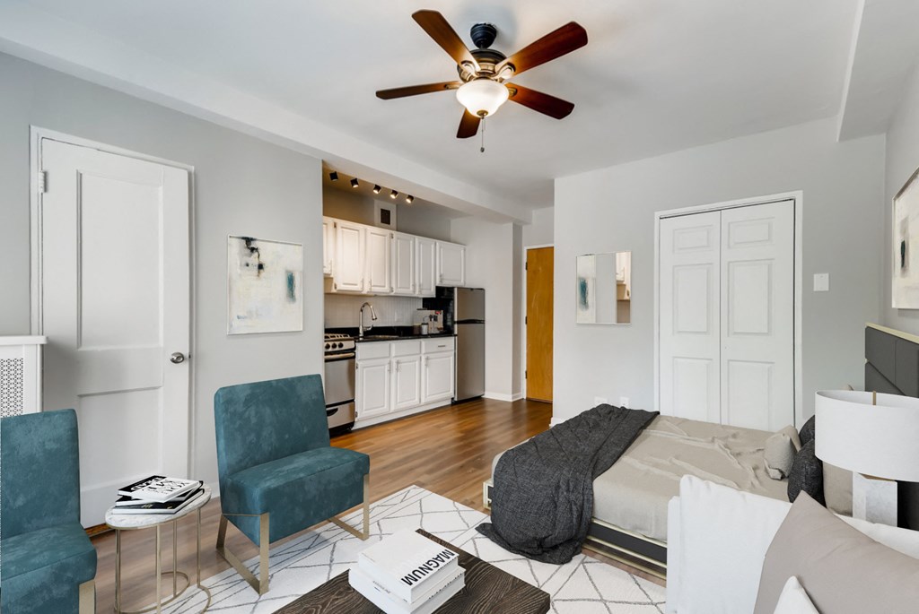 a living room with a bed and a ceiling fan