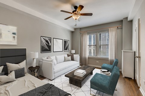 a living room with a white couch and a ceiling fan