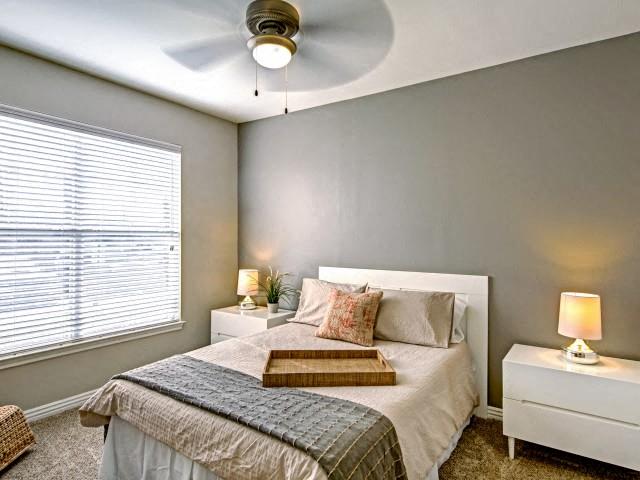 Bedroom with ceiling fans and plush carpet