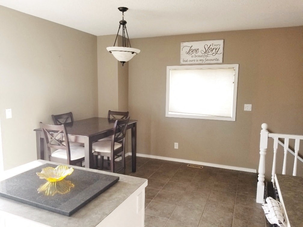 a dining room with a table and chairs and a window