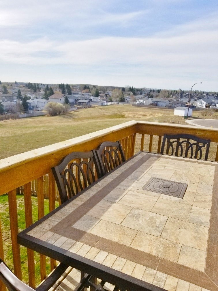 a balcony with a table and a view of a field