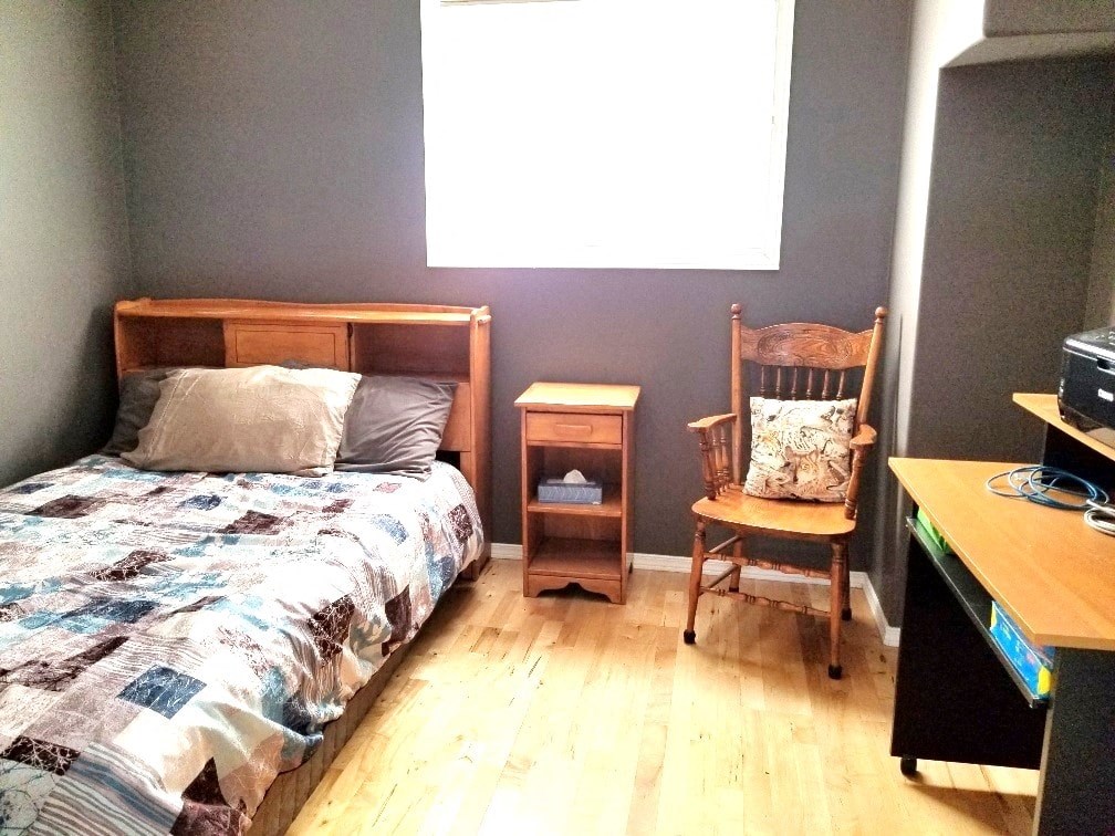 a bedroom with a bed and a chair and a desk