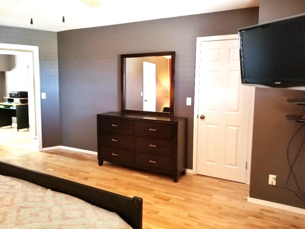 a bedroom with a dresser and a tv