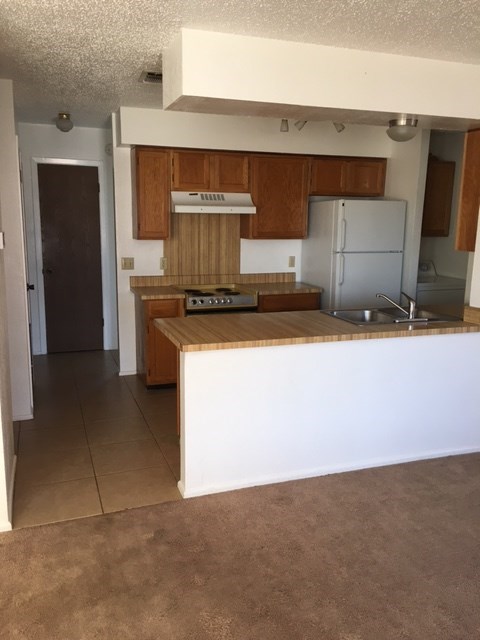 an empty kitchen with a white counter top