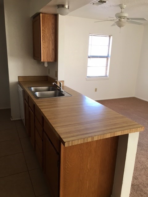a kitchen with a wooden counter top and a sink